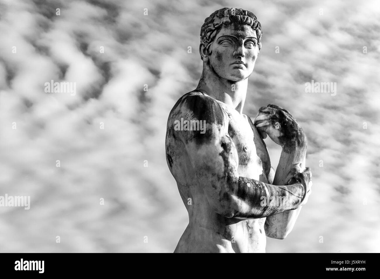 Idealizzato statua in marmo di un atleta a Roma Stadio dei Marmi drammatico sky Foto Stock