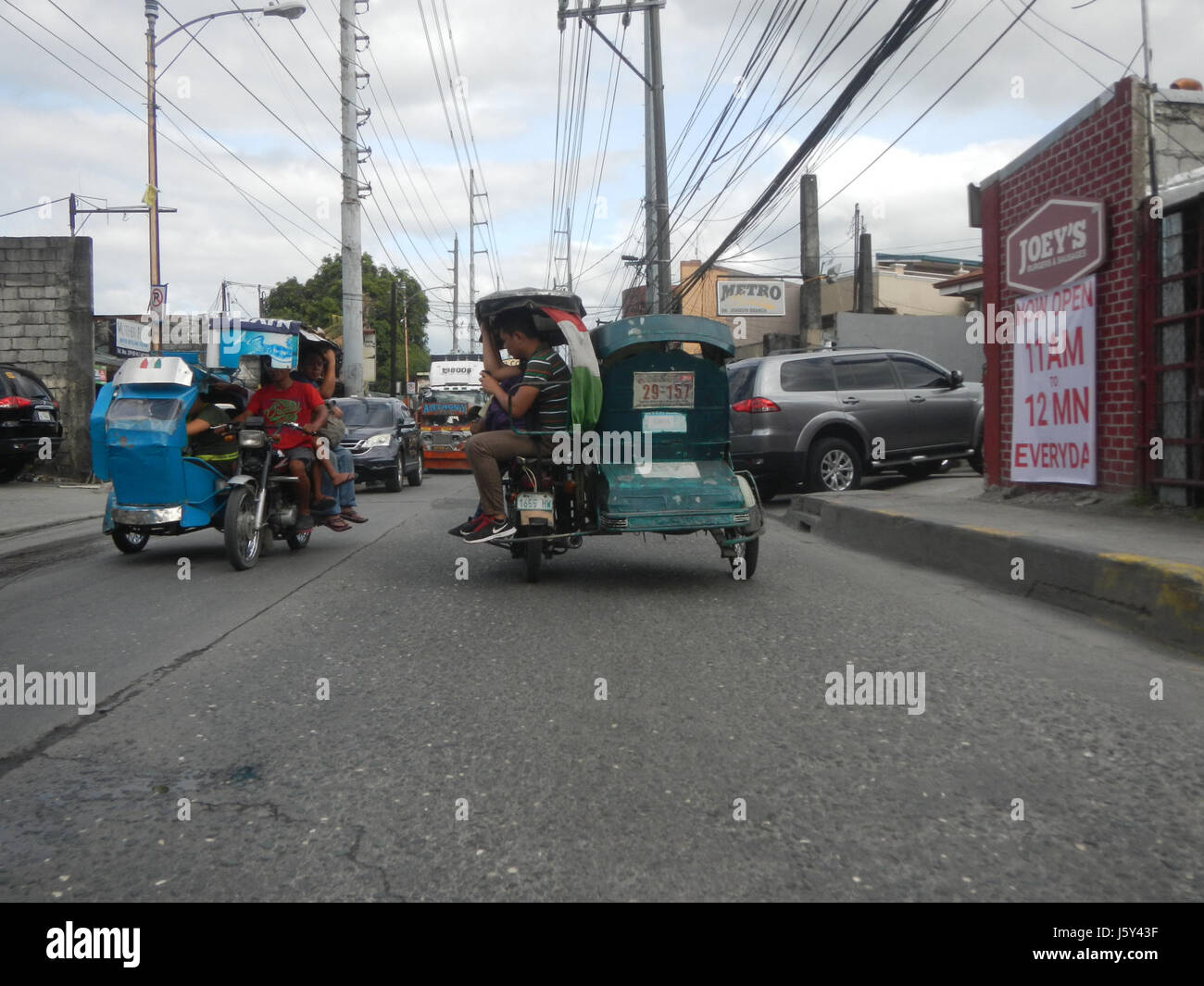 Questa immagine mostra Elisco Road a San Joaquin, Kalawaan, Pasig City, vicino alla Kalawaan High School. La vista enfatizza l'ambiente urbano e le infrastrutture di questa zona della città di Pasig. Foto Stock
