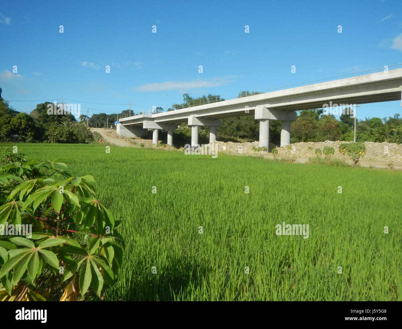 Questa immagine cattura lo sviluppo della fase II dell'Arterial Road bypass Project a San Rafael, Bulacan, mostrando la trasformazione delle risaie della regione. Foto Stock
