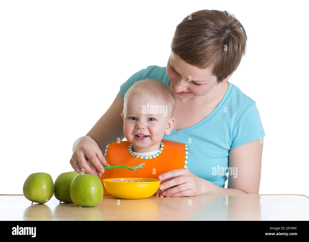 Cucchiaio di madre-alimentando il suo bambino isolato su bianco Foto Stock