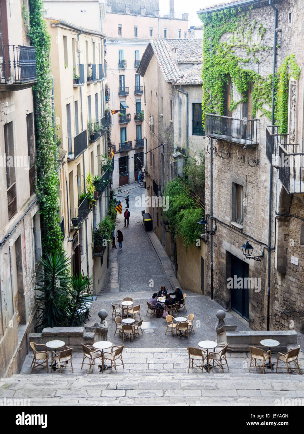 Guardando in giù per le scale di Pujada de Sant Domènec a tavoli e sedie per pranzare al fresco nella città di Girona, Spagna. Foto Stock