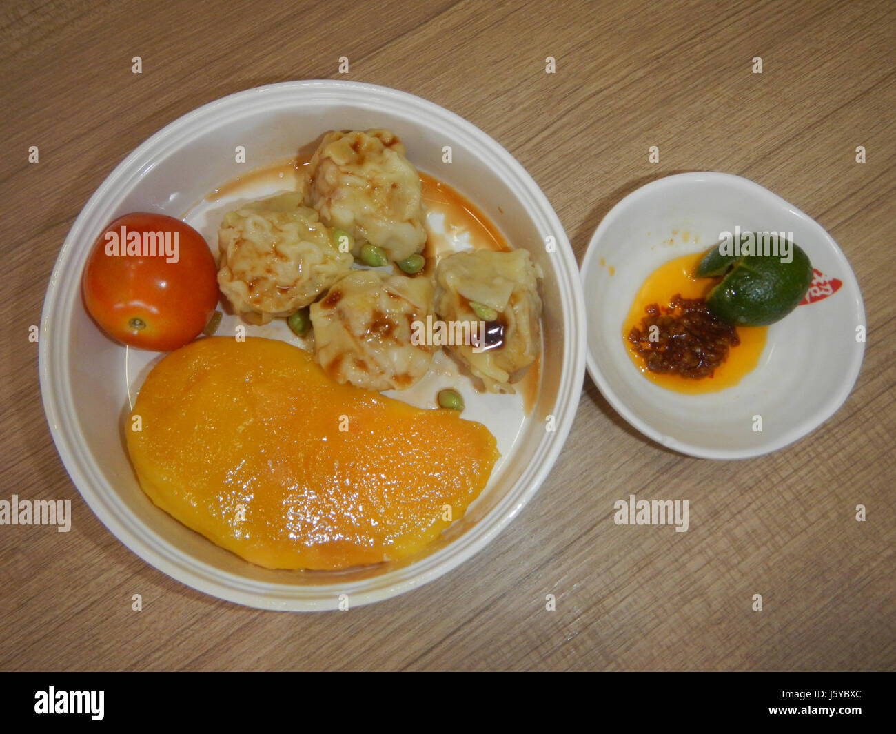 Il Siomai di Bulacan è un popolare piatto locale a base di carne macinata, spesso maiale, avvolto in un impasto sottile e cotto al vapore. È comunemente servito come spuntino o antipasto nella cucina filippina, riconosciuta per i suoi saporiti ripieni e il significato culturale nelle tradizioni culinarie di Bulacan. Foto Stock