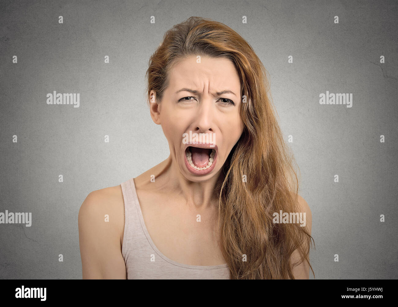 Ritratto arrabbiato sconvolto donna urlando piangendo ampia bocca aperta faccia isterica grimace isolato muro grigio Sfondo.negativo espressione umana emozione ba Foto Stock