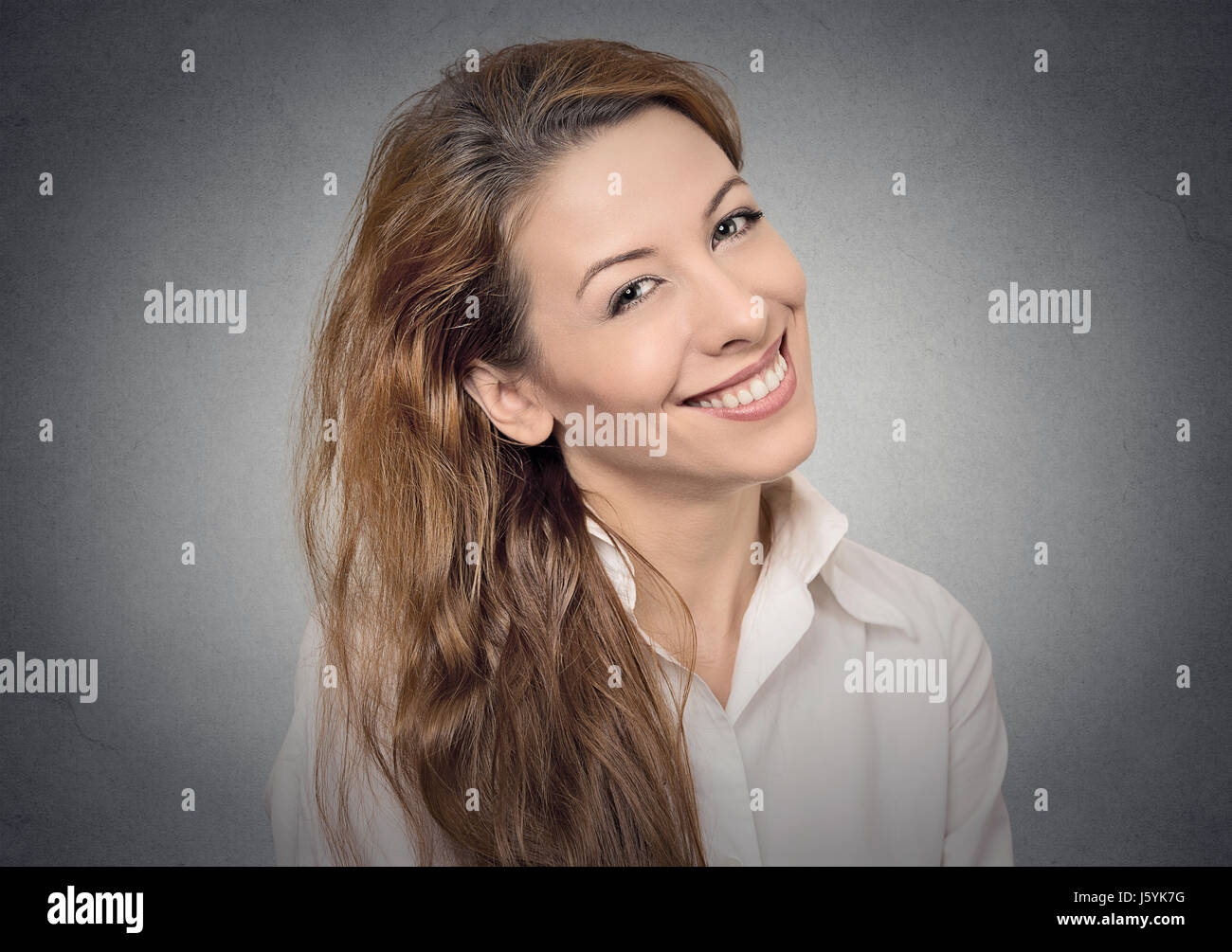 Bella ragazza sorridente sul muro grigio Sfondo. positivo emozioni umane, faccia espressioni, sentimenti Foto Stock
