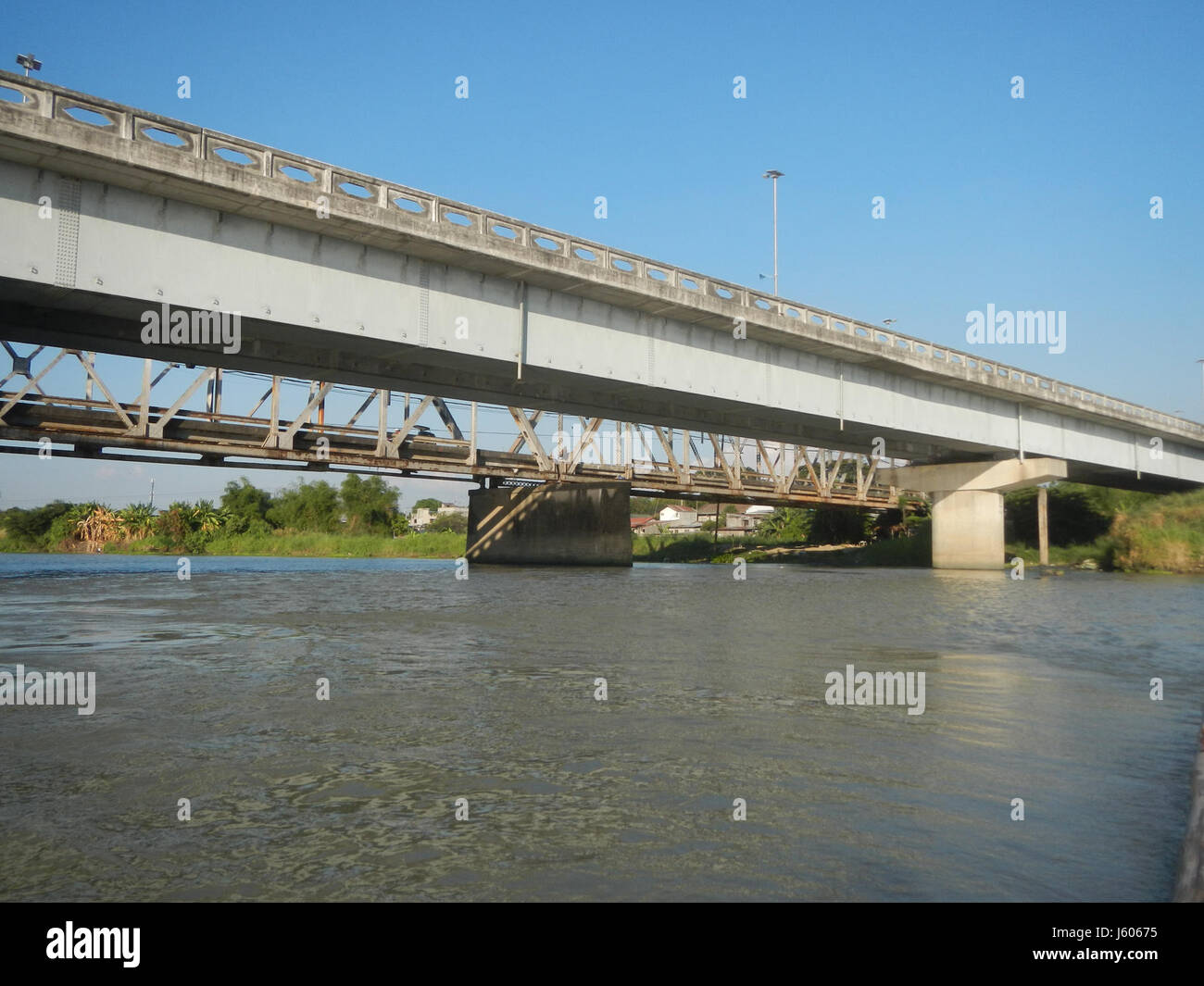 I ponti Old e New Sulipan Apalit nell'area di Calumpit di Bulacan e Pampanga, Filippine, si estendono lungo il fiume Pampanga, collegando i distretti locali. Questi ponti sono vitali per i trasporti nella regione, contribuendo all'economia locale e all'accessibilità della comunità. L'immagine risale al 2017 e mostra le infrastrutture moderne e storiche affiancate. Foto Stock