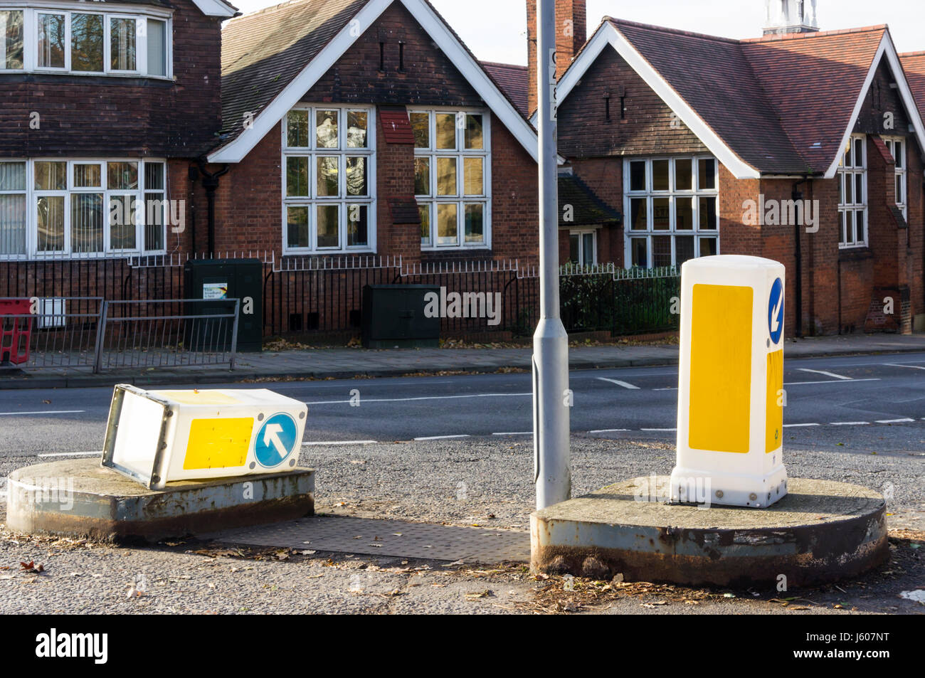 Bollard plastica abbattuti su un semaforo con un isola. Foto Stock