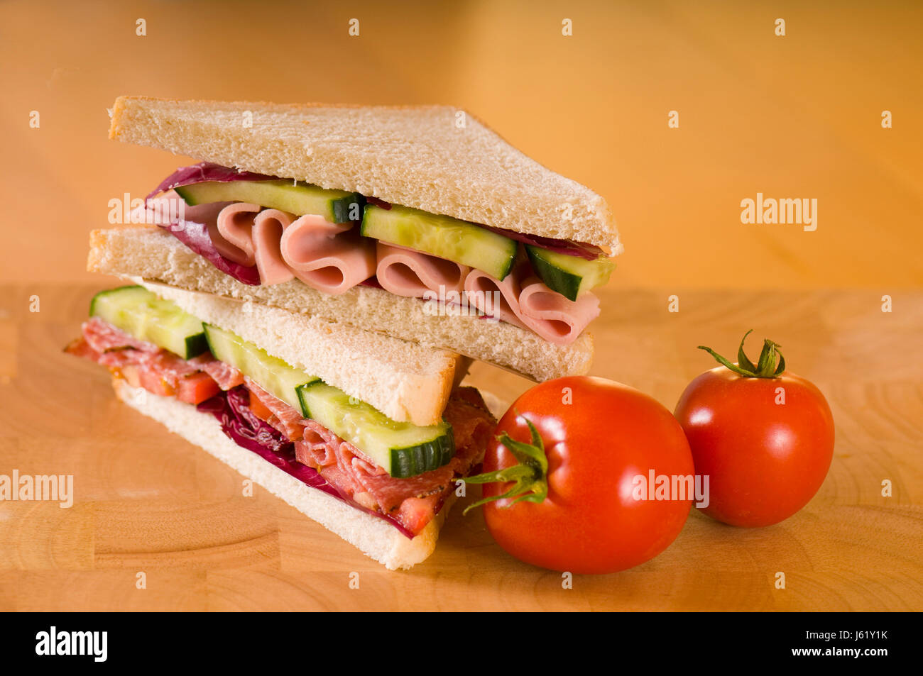 Sandwich di pane tostato tagliare gli angoli di salame salsiccia dimezzato il pane di legno verde vuoto Foto Stock