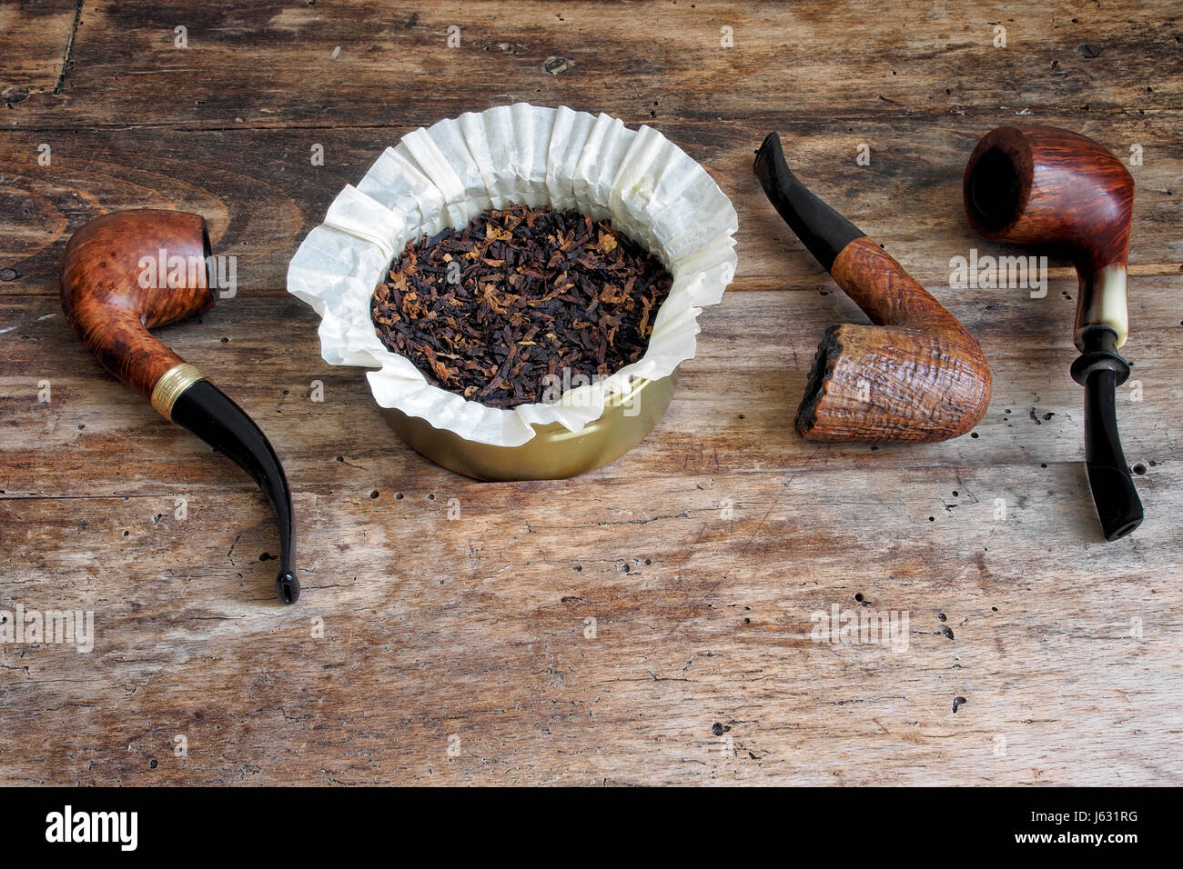 Tubi di legno e di tabacco nella scatola di metallo su un tavolo di legno. Foto Stock