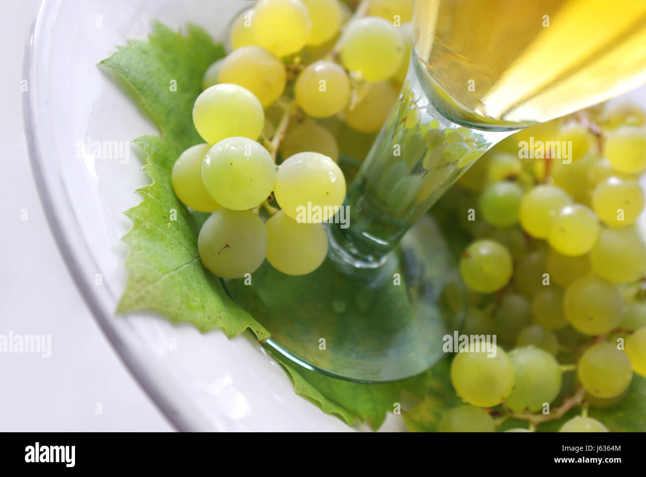 Il vetro di un calice di vino uve glas piastra tarda estate grappoli di uva vino bianco Foto Stock
