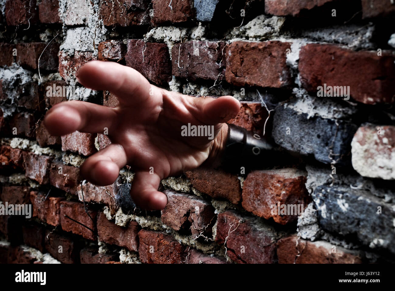 Lato parete composizione fotografica paura orrore impotente murata in mano a gabbia dito Foto Stock