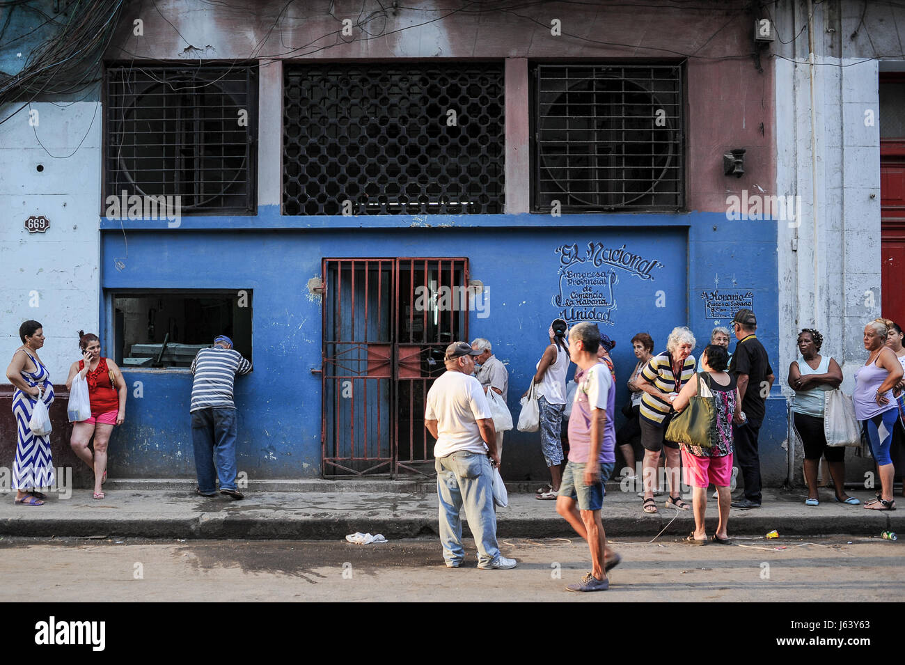 Cubani locali queueing presso un negozio di macelleria in Neptuno street, Havana, Cuba Foto Stock