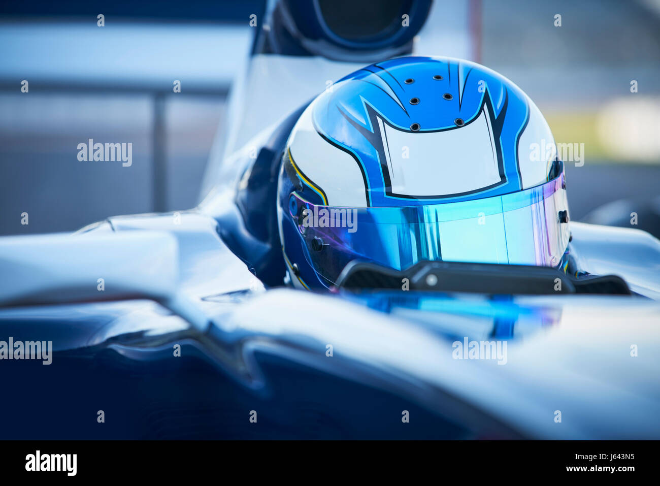 Vicino la gara di Formula Uno pilota di auto che indossa il casco blu Foto Stock