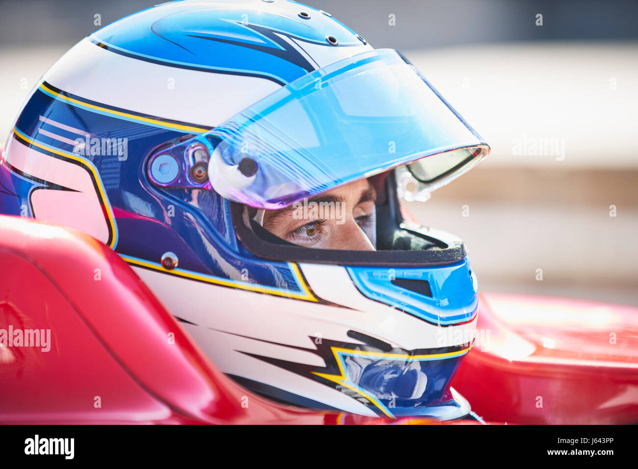 Vicino la gara di Formula Uno pilota di auto nel casco che guarda lontano Foto Stock