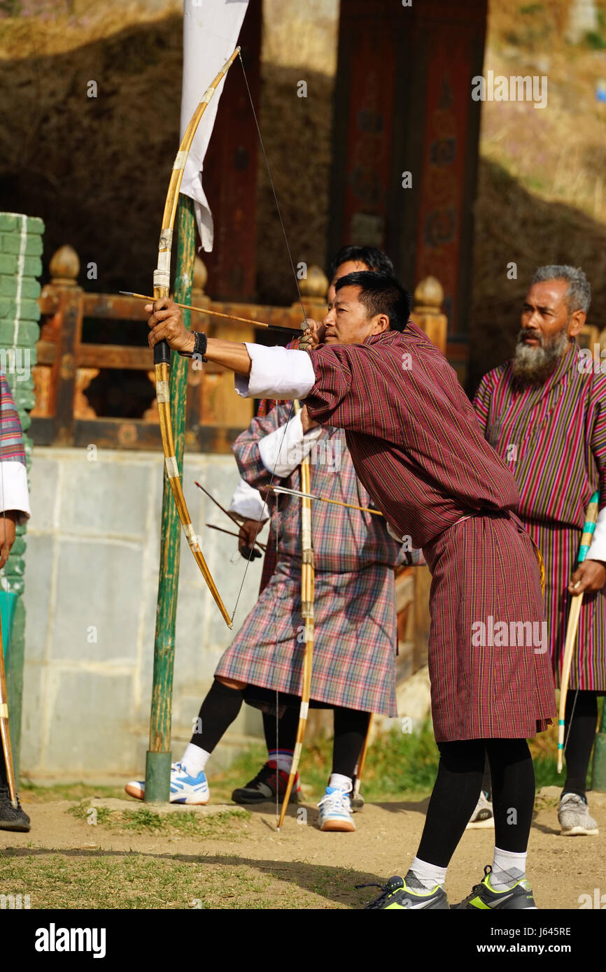 Uomo in abbigliamento tradizionale tiro con arco una freccia a Thimphu Bhutan Foto Stock