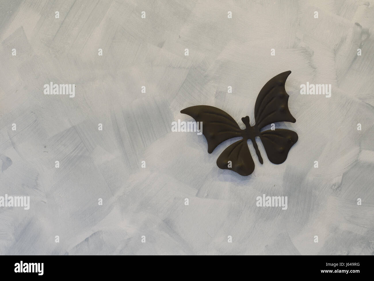 Farfalla di ferro su sfondo di cemento Foto Stock