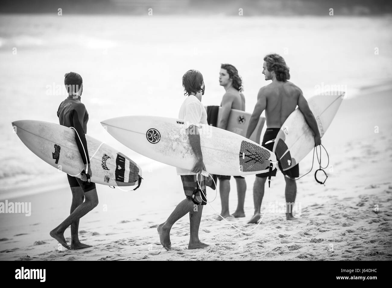 RIO DE JANEIRO - Ottobre 27, 2015: giovane brasiliano surfers a piedi con le loro tavole da surf a Arpoador, il popolare punto surf alla fine della spiaggia di Ipanema. Foto Stock