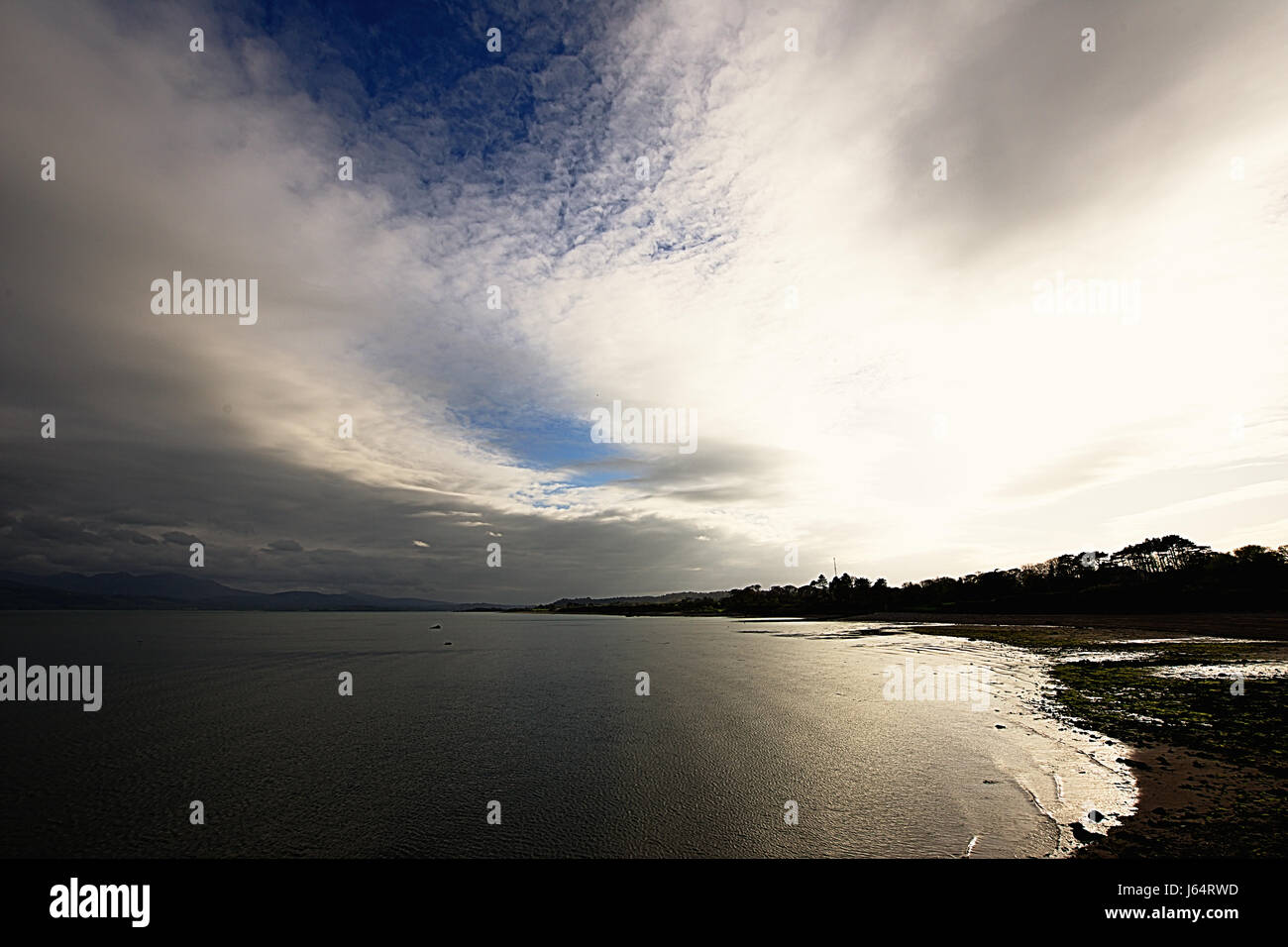 Paesaggio di Anglesey.bello,drammatico cielo nuvoloso sopra Beaumaris sulla spiaggia di primavera pomeriggio.Il nord del Galles,Uk.British paesaggio in primavera.uk costa. Foto Stock