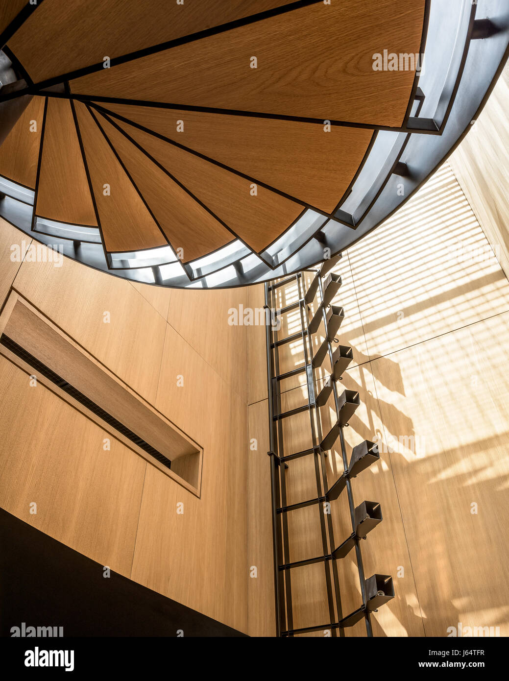 White Impiallacciatura di rovere e acciaio nero scala a spirale. Il nero angolato accessori per luce di funzionamento fino alla parete sono stati progettati da Bernard Khoury Foto Stock