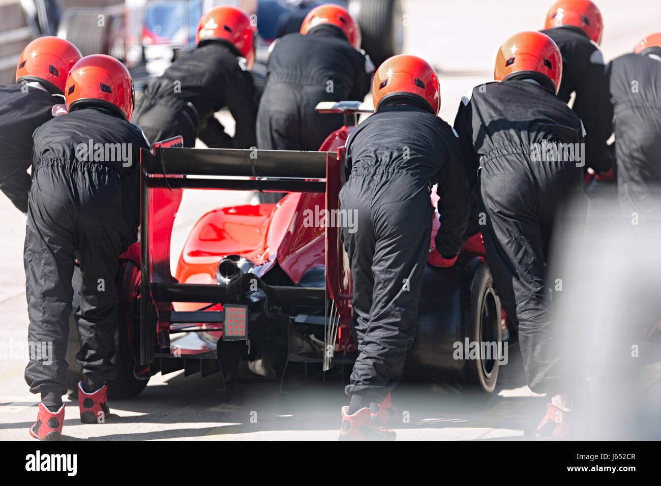 Pit Crew spingendo gara di Formula Uno auto al di fuori della pit lane Foto Stock