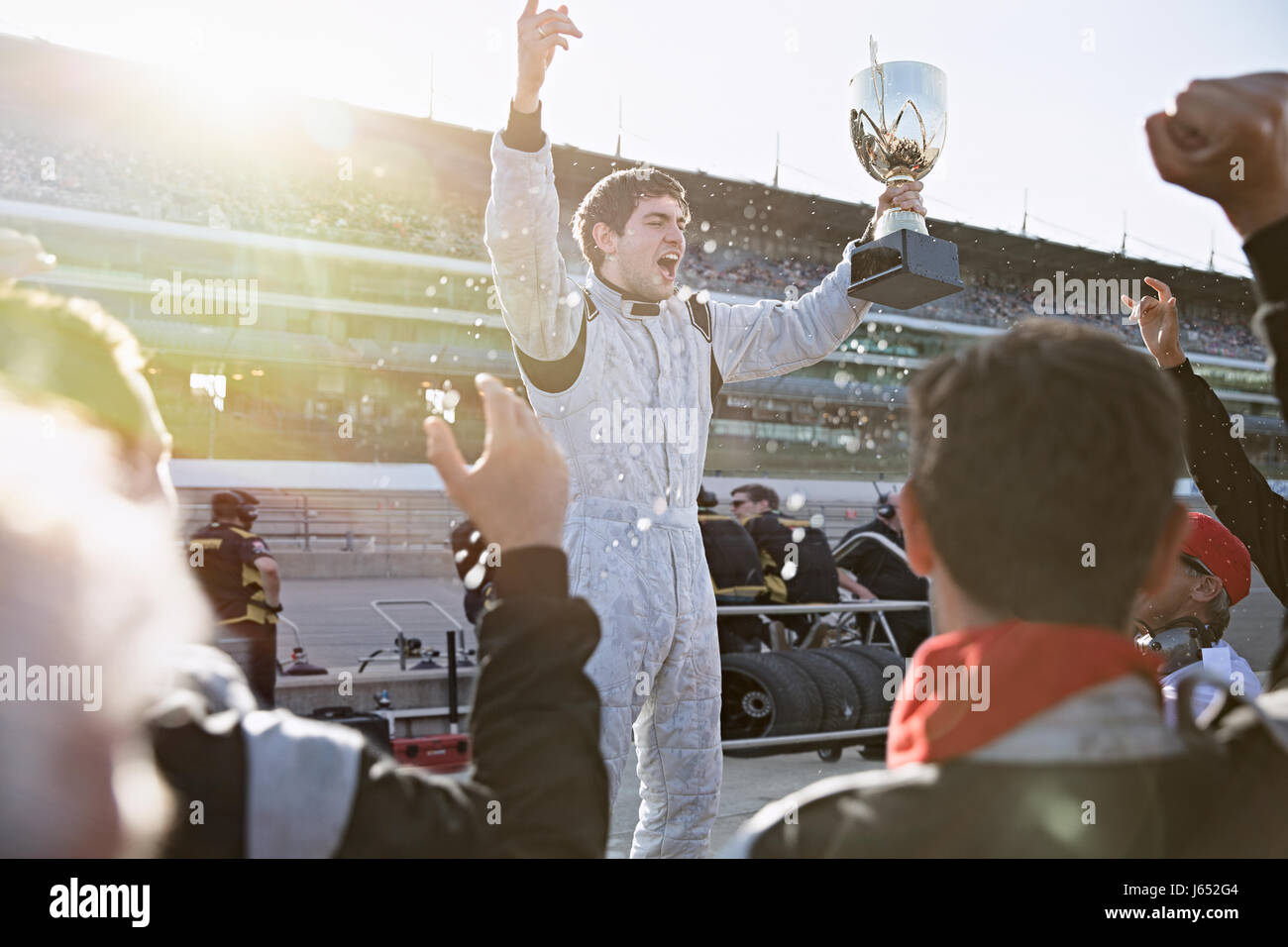 Formula One racing team il tifo per driver con trofeo, celebrando la vittoria su sport via Foto Stock