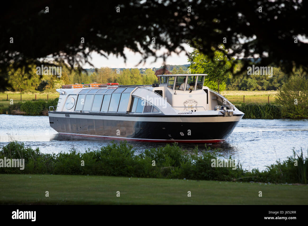 Un grande piacere in barca a vela lungo il fiume Thames attraverso campi erbosi adn sotto basso appeso alberi vicino a Henley NEL REGNO UNITO Foto Stock