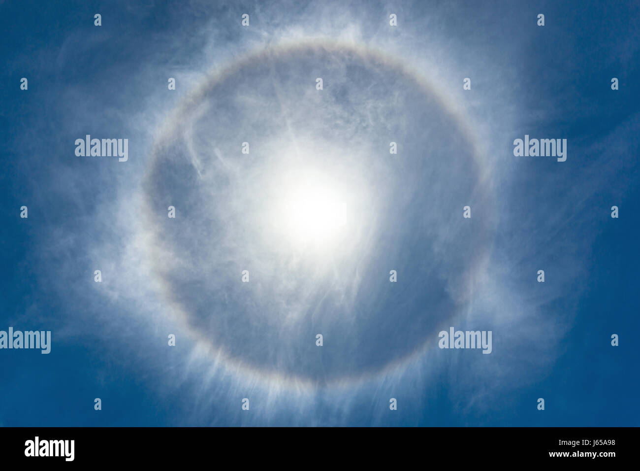 Guardando verso l'alto un alone attorno al luminoso sole di mezzogiorno. Un altro caldo e umido giorno su un tropicale isola caraibica paradiso. Foto Stock