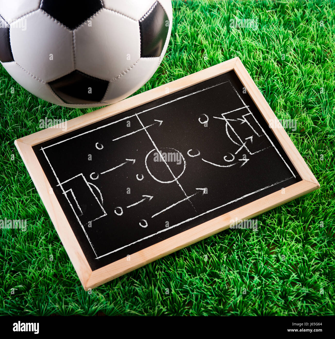 Lavagna con tattiche di gioco con pallone da calcio e tappeto erboso verde  sullo sfondo Foto stock - Alamy