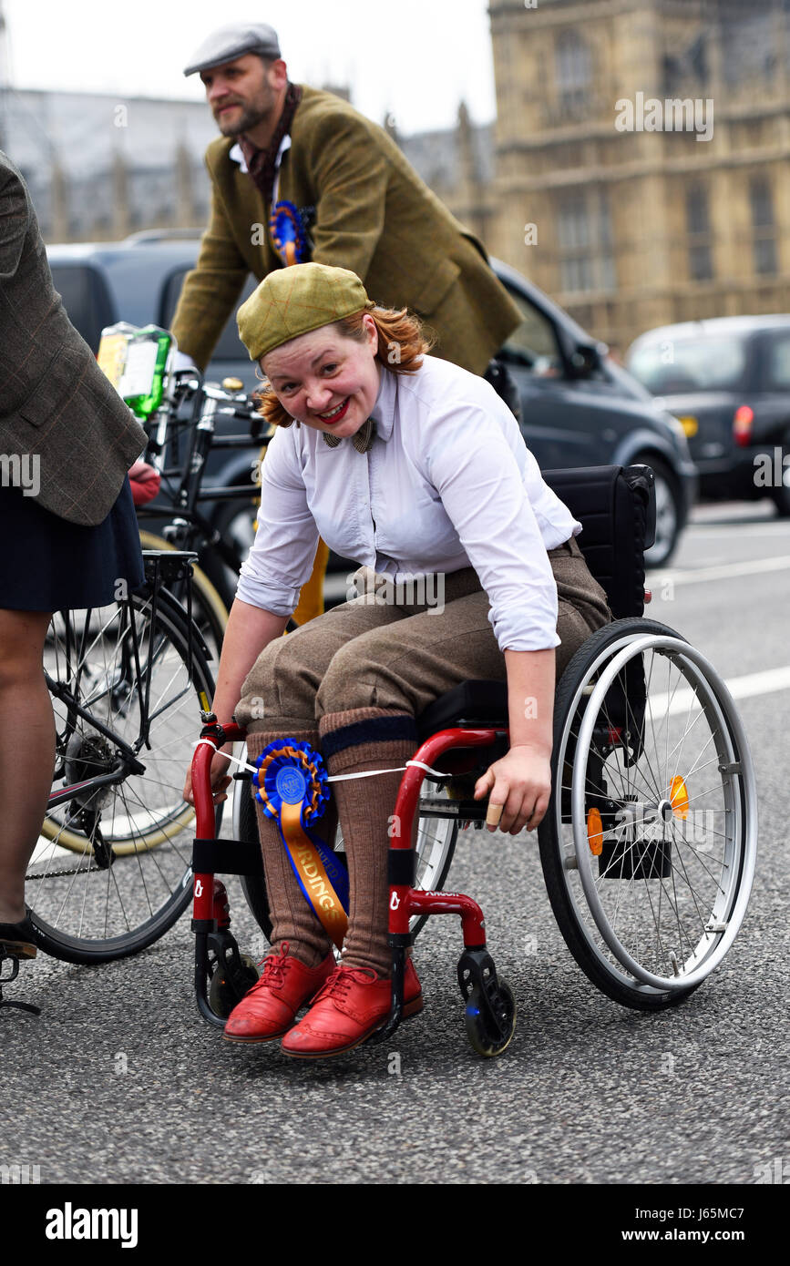 Tweed Run partecipante in sedia a rotelle a Londra attraversando il Westminster Bridge passando per le camere del Parlamento Foto Stock