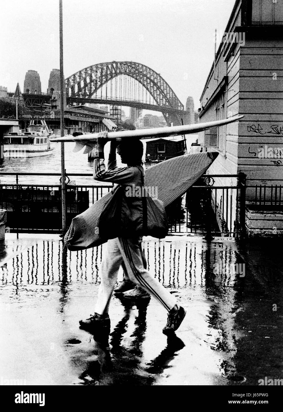 AJAXNETPHOTO. 1987. SYDNEY, Australia. - GONE SURFIN' - Un giorno di pioggia vicino al Circular Quay, il famoso ponte in background. foto:JONATHAN EASTLAND/AJAX. REF:0287 Foto Stock