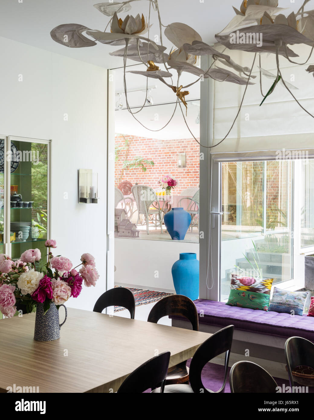 Oak sormontato tavolo con sedie vintage e il montaggio della luce in un livello diviso Bruxelles atelier Foto Stock