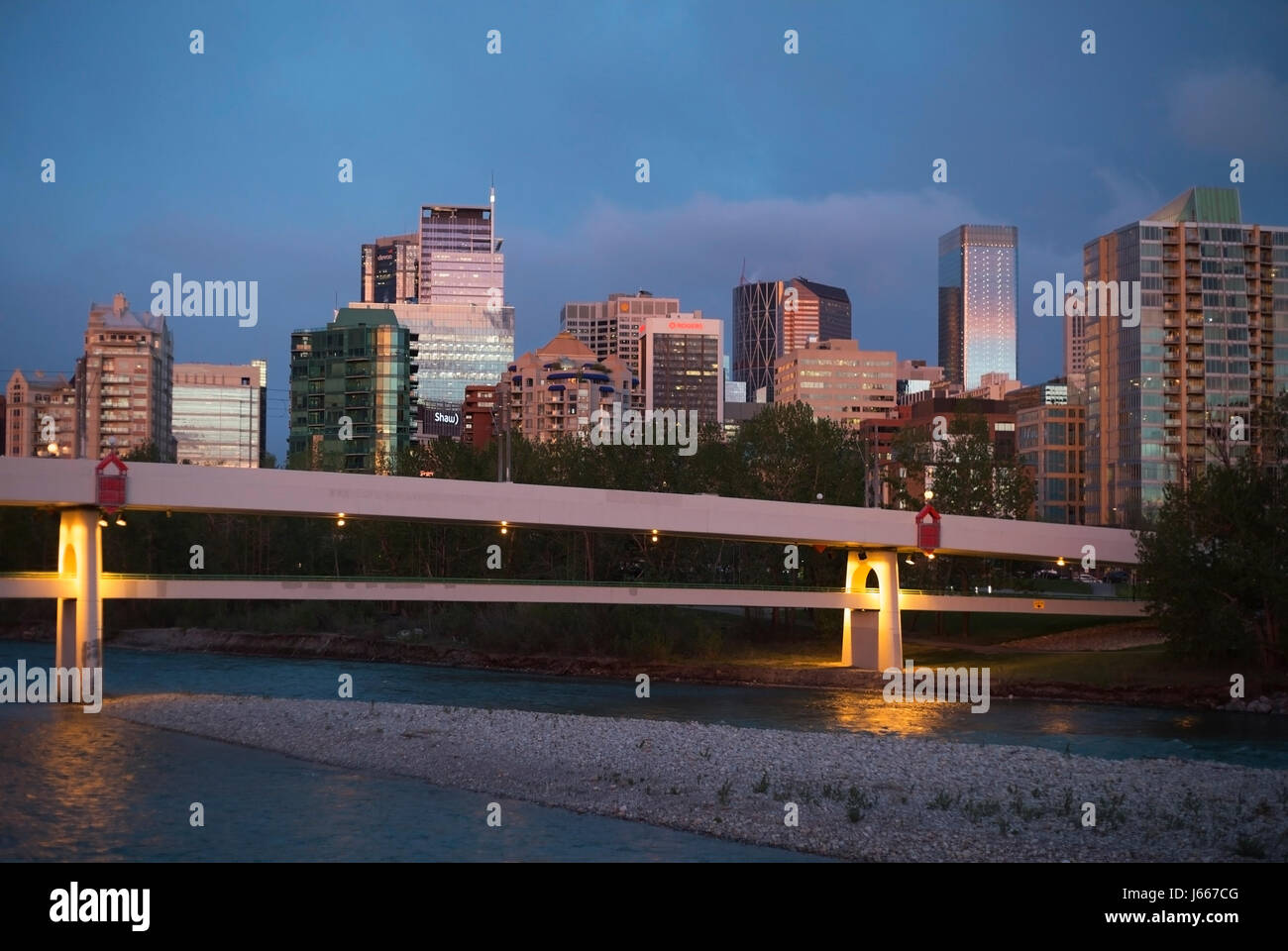 Ponte di CTrain con un ponte pedonale sul ponte inferiore attraverso il Fiume Bow al centro di Calgary Foto Stock