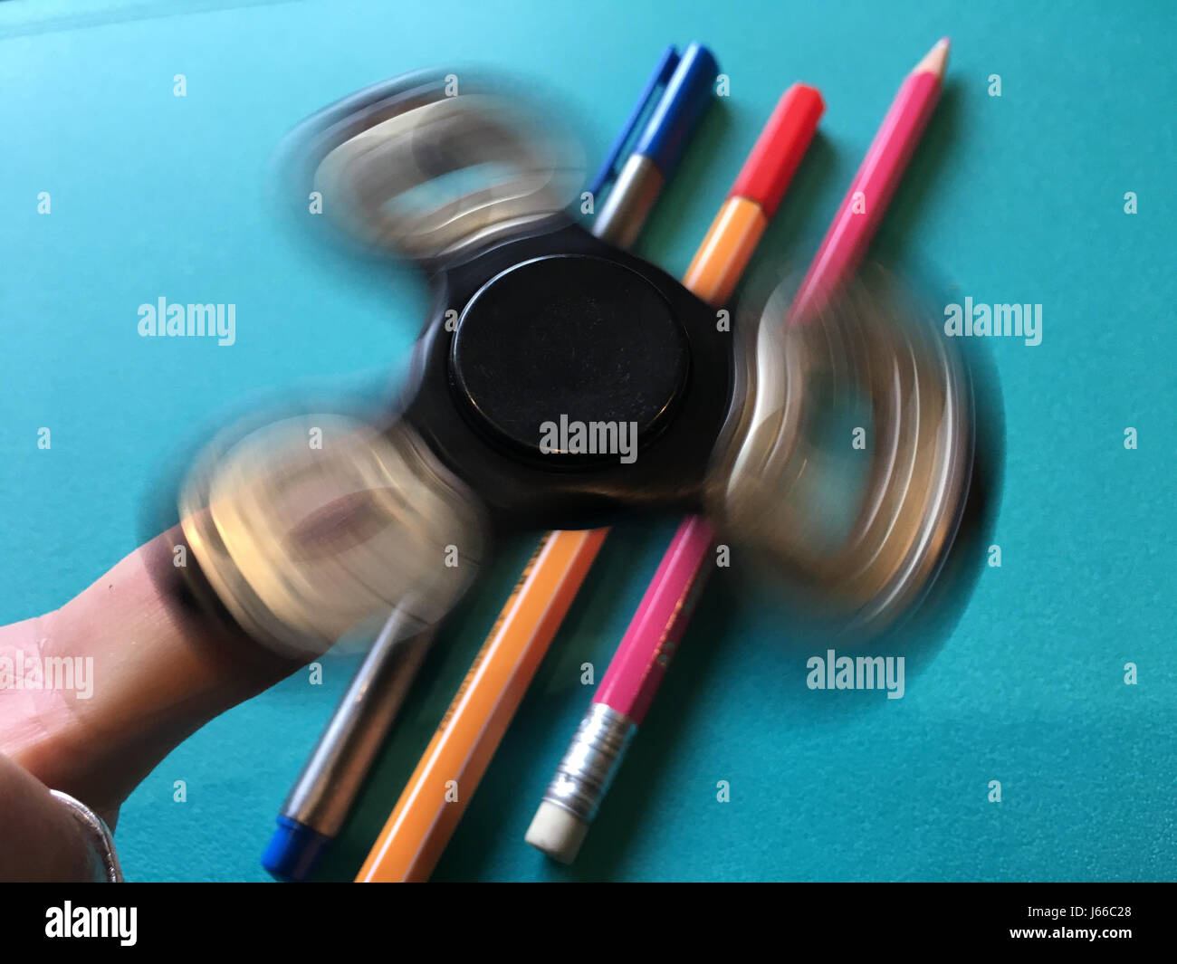 Agitano: spinner, filatura su un singolo dito sopra di penne e matite Foto Stock