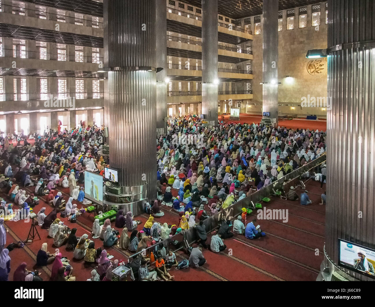 Jakarta, Indonesia - 11 Gennaio 2015: la grande sala per le donne, riempito con le donne con colorate sciarpe di testa. La Moschea Istiqlal / Masjid Istiqlal, l Foto Stock