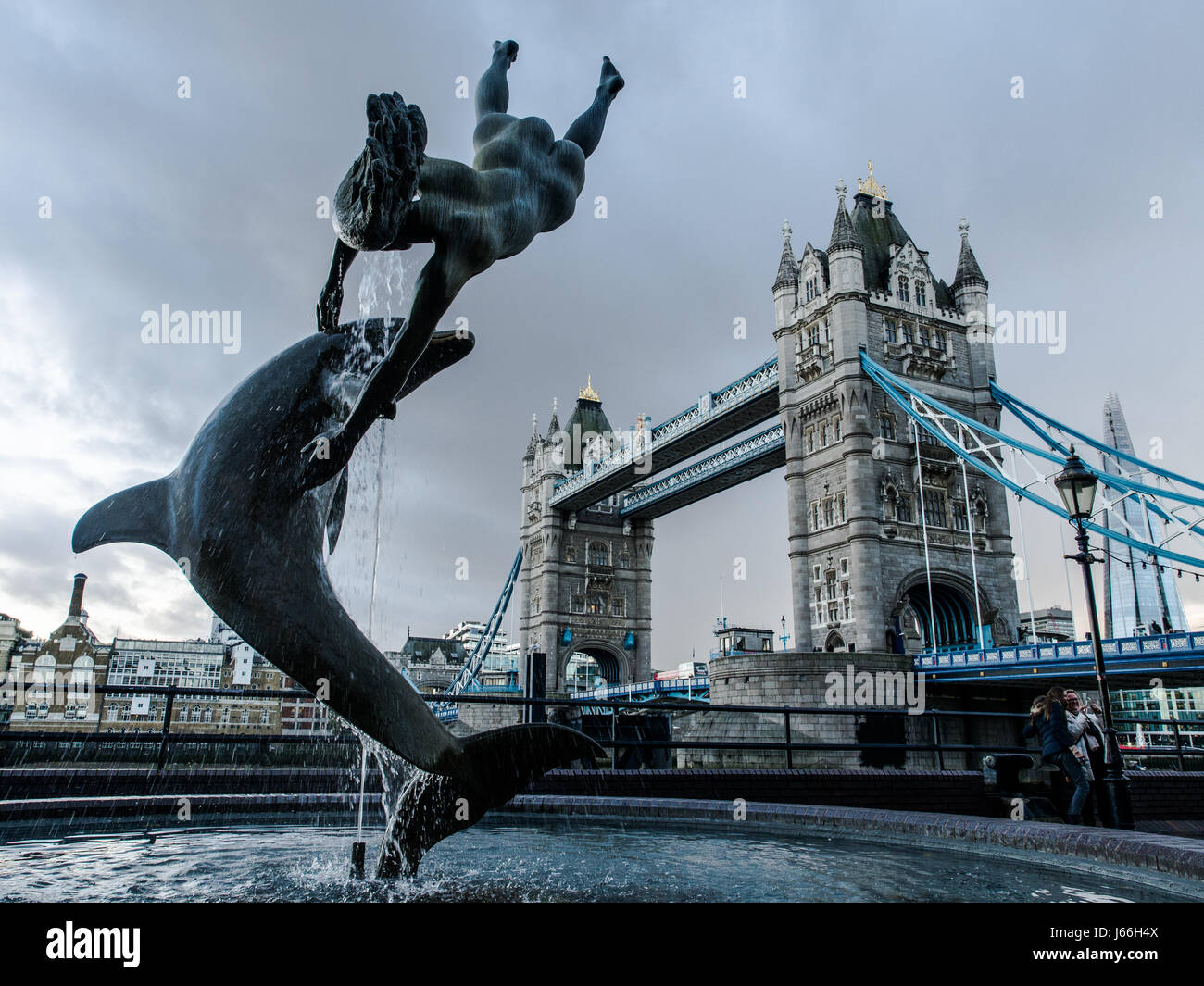 Londra, Inghilterra - Dicembre 08, 2015: una fontana con un delfino, in un giorno nuvoloso con gli storici il Tower Bridge di Londra in background Foto Stock