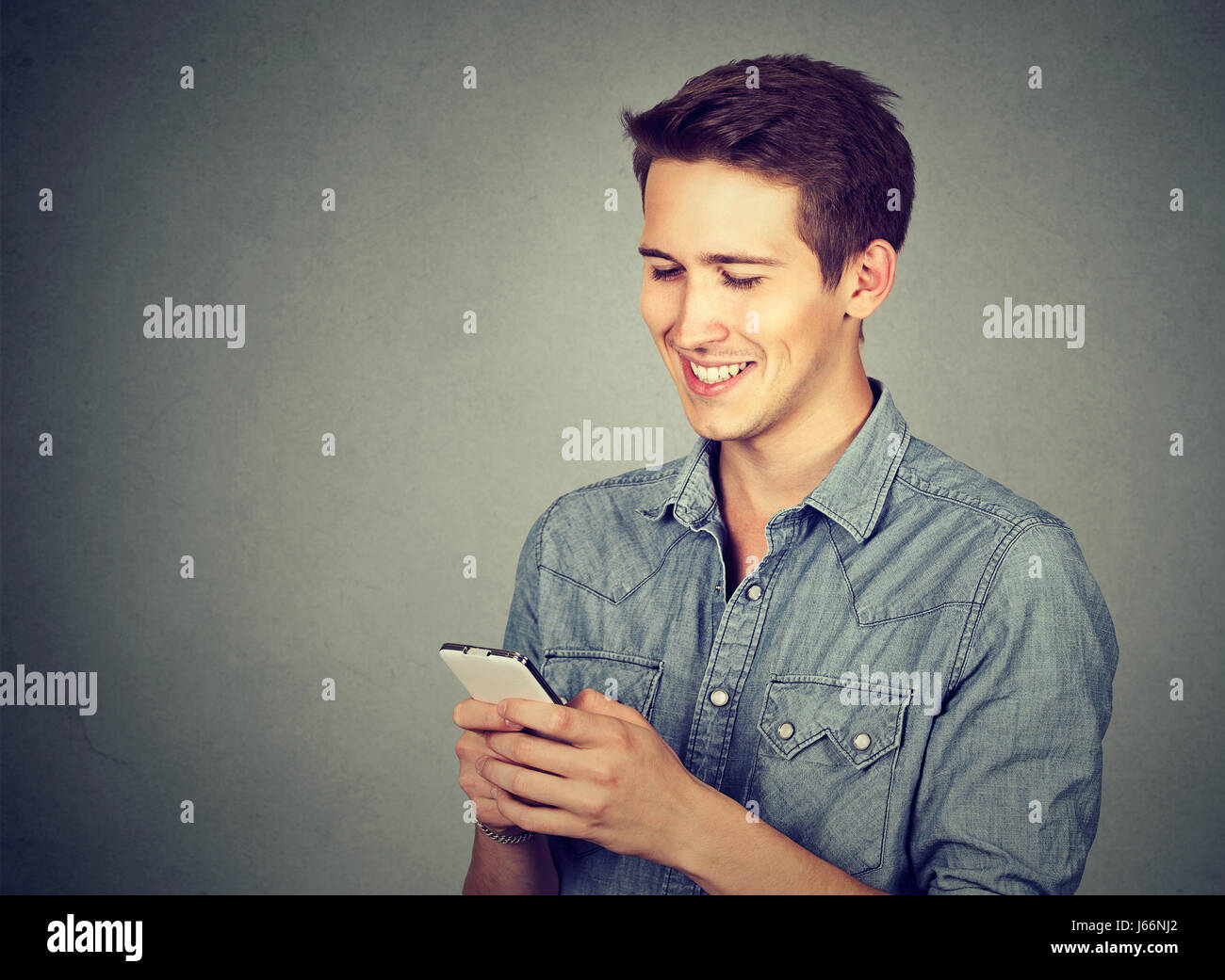 Felice l'uomo tramite telefono cellulare SMS Foto Stock