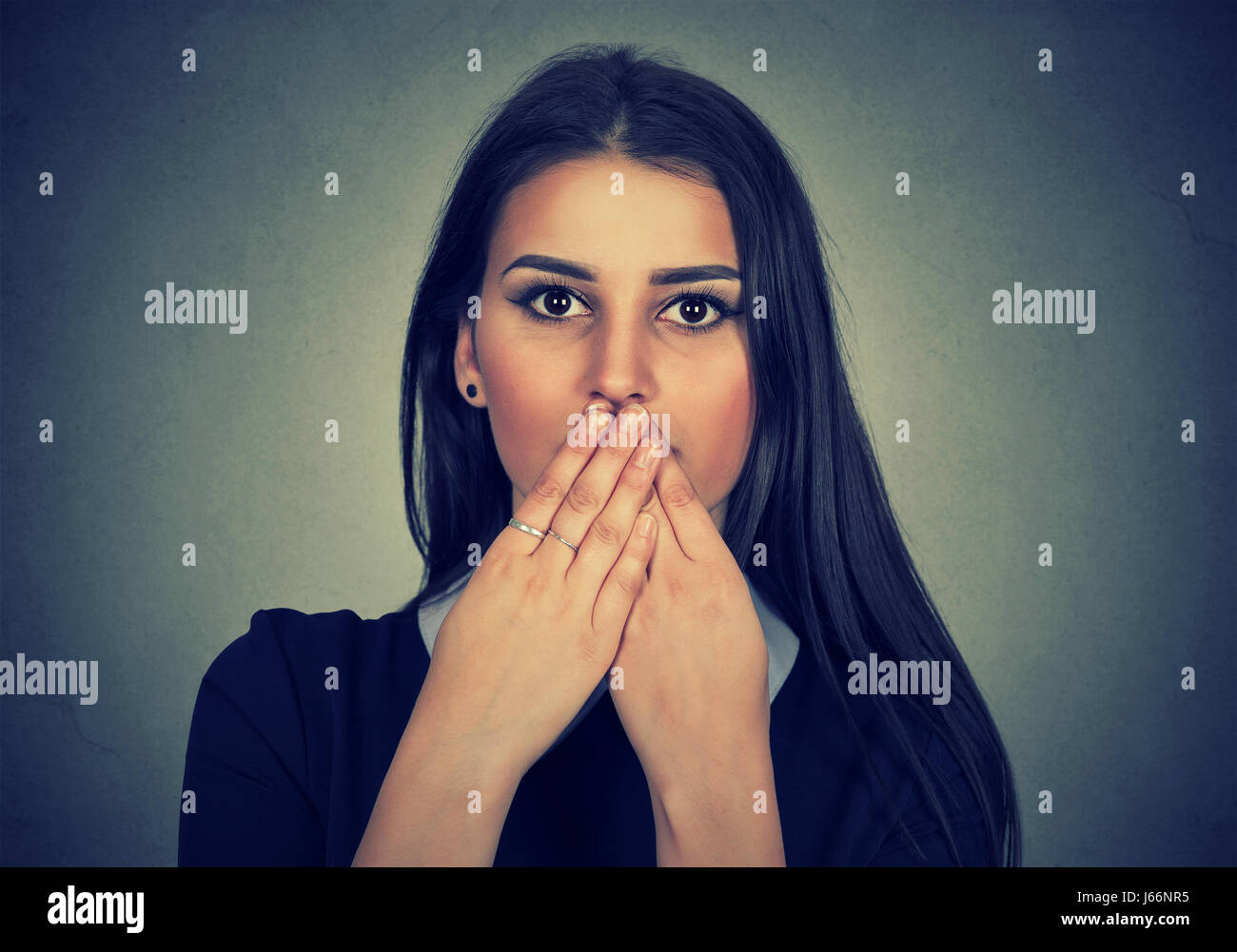 Brunette donna si copre la bocca con le mani Foto Stock