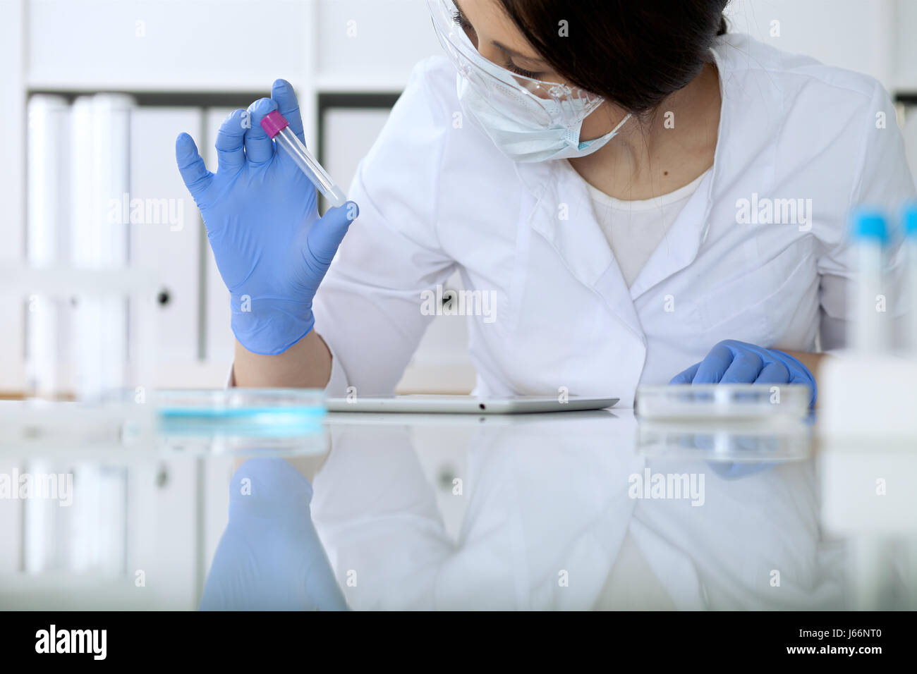 Close up ricerca scientifica le mani con soluzione chiara in laboratorio Foto Stock