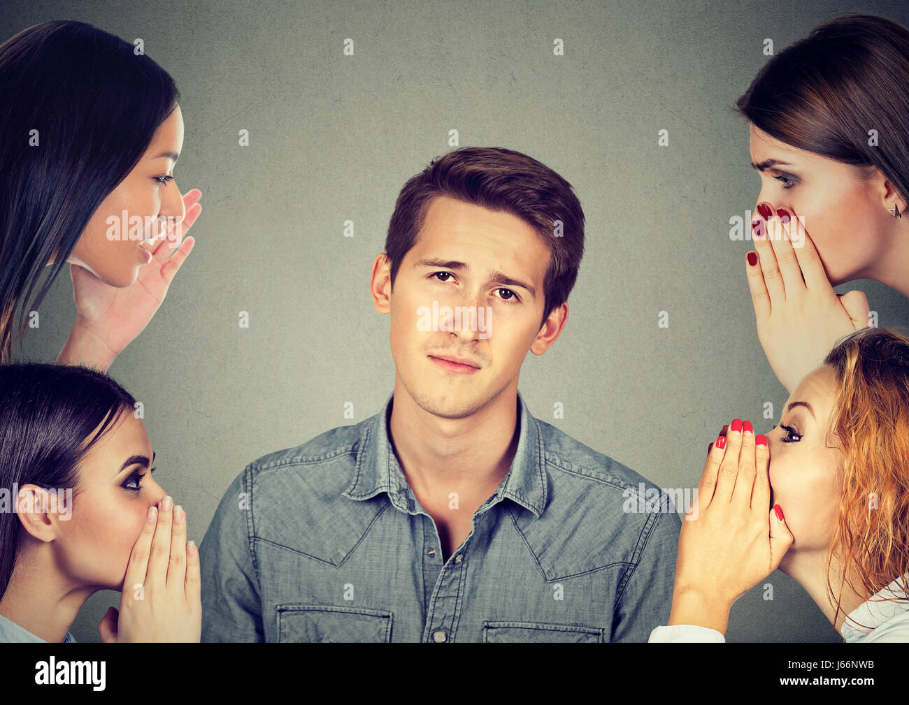 Quattro donne sussurra un segreto gossip più recenti di un annoiato infastidito l'uomo Foto Stock