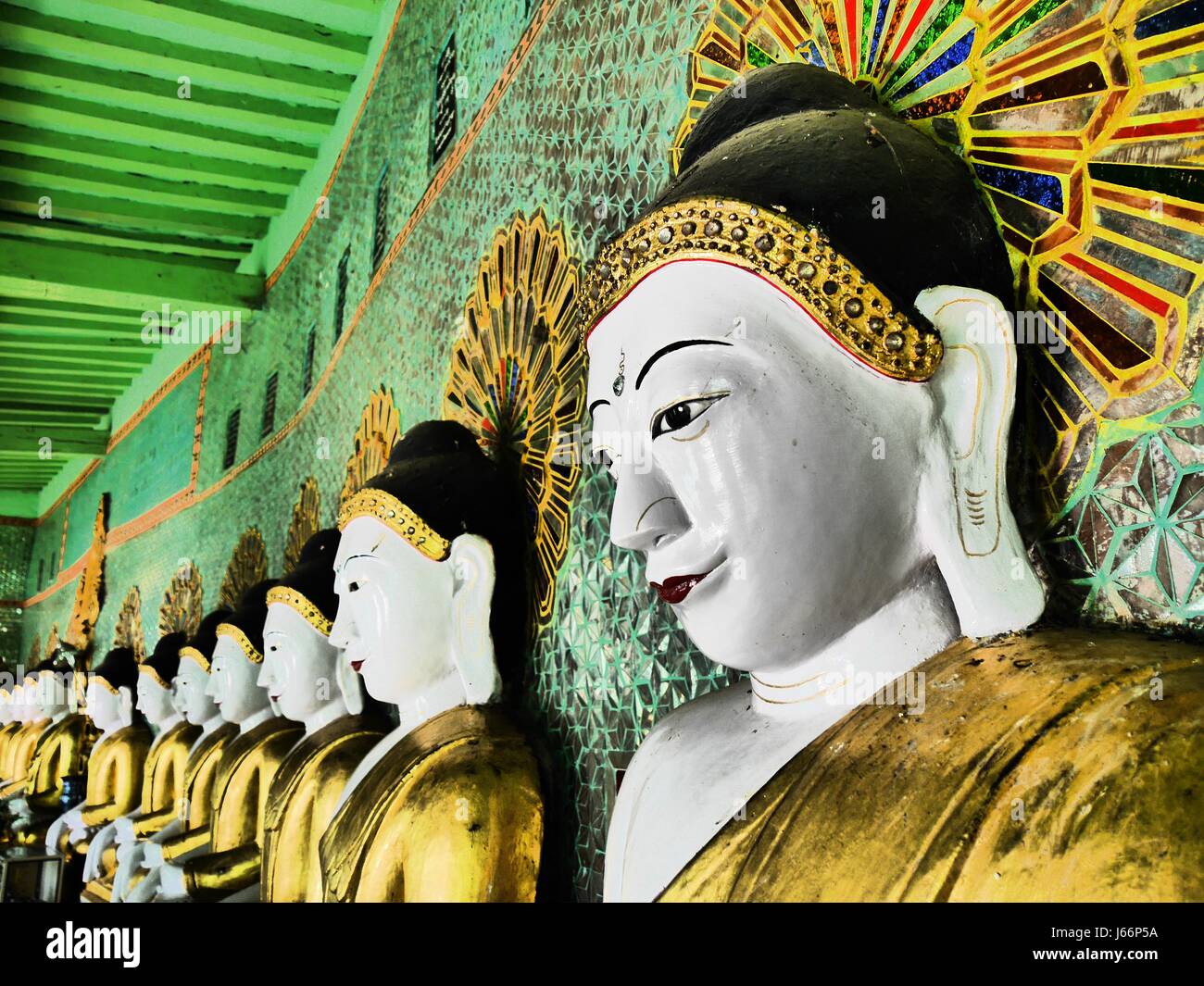 Terrazza buddista (Umin Thounzeh) sulla collina di Sagaing, Myanmar. A forma di mezzaluna colonnato di 45 statue di Buddha con uno in foregound e la riga a sinistra Foto Stock