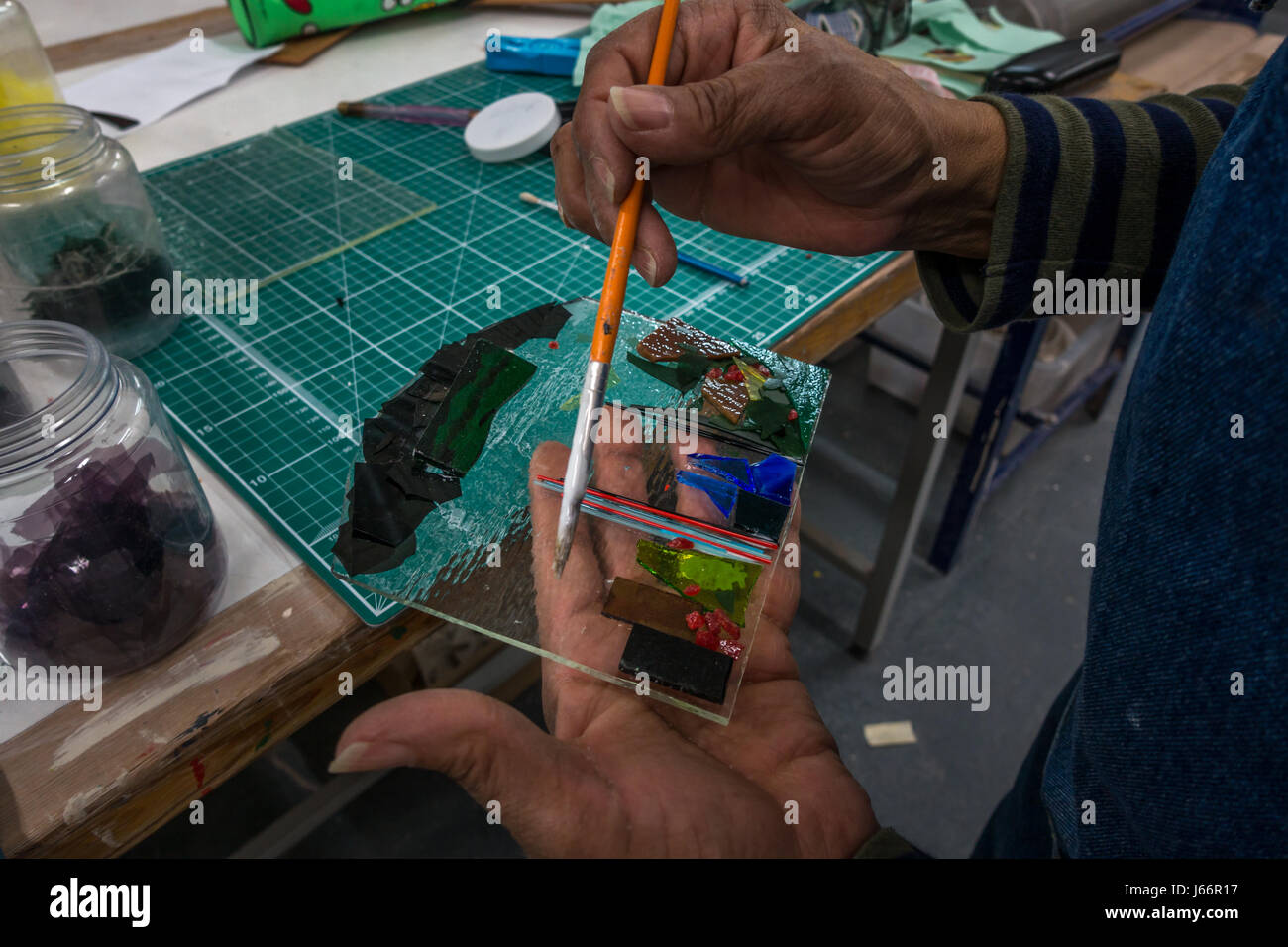 Persona che crea una fusione del vetro pezzo, decorare usando un pennello, REGNO UNITO Foto Stock