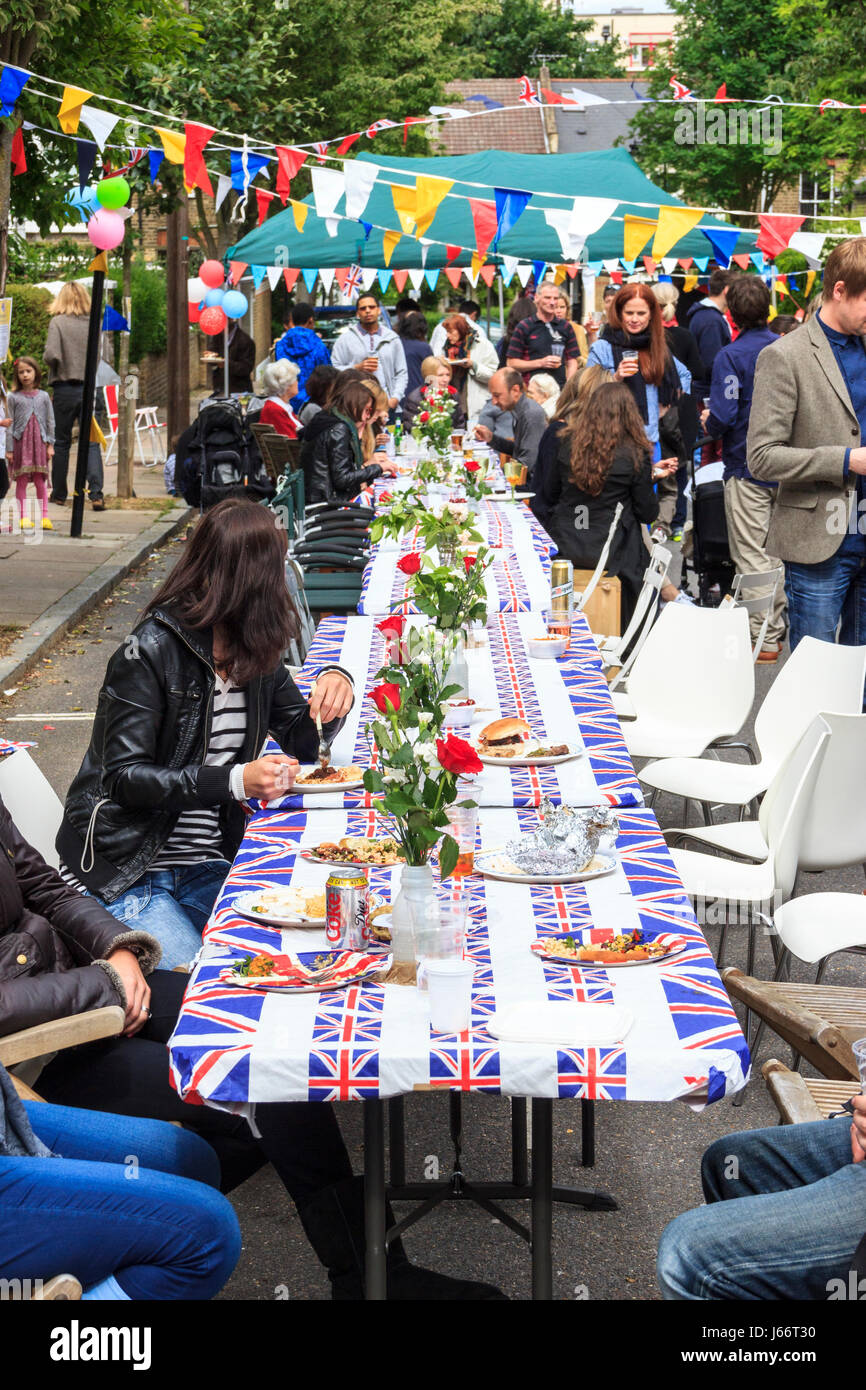 I residenti locali di raccolta comunale per il cibo e le bevande in un Giubileo partito street, a nord di Londra, UK, 2012 Foto Stock