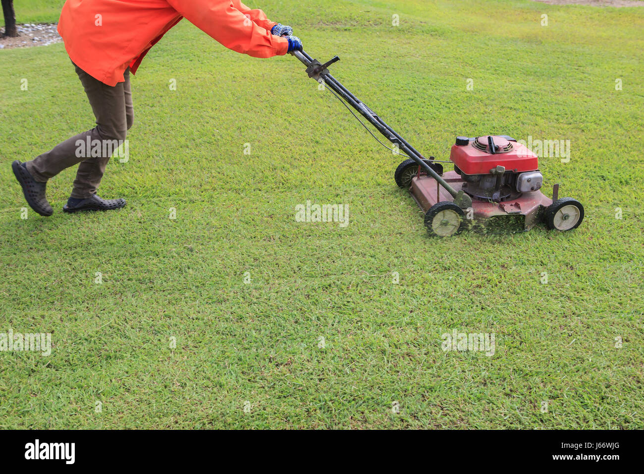 Lavoratore il taglio di erba verde campo da prato motore mover Foto Stock