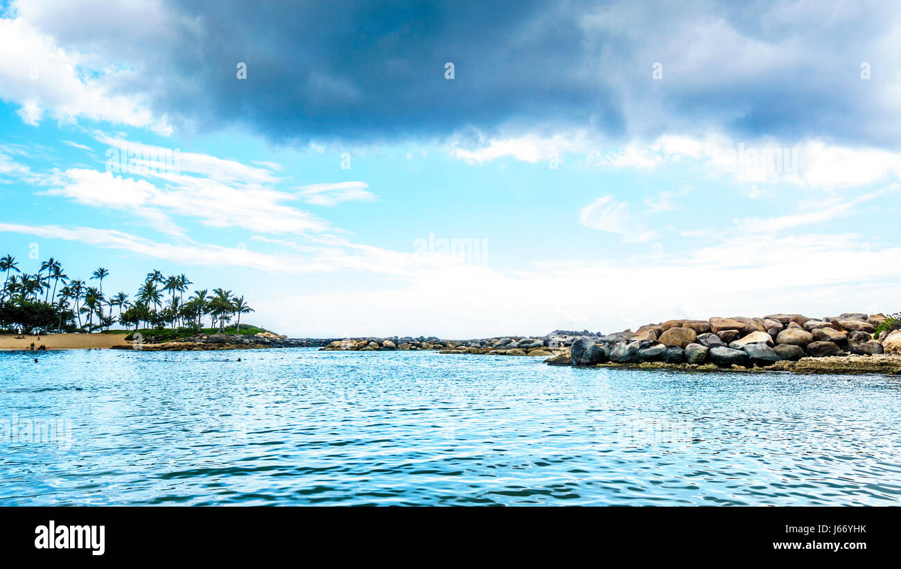 Alberi di palma nel vento al Ko Olina lagune sotto il cielo nuvoloso presso le lagune di Ko Olina sulla costa ovest dell'isola hawaiana di Oahu Foto Stock