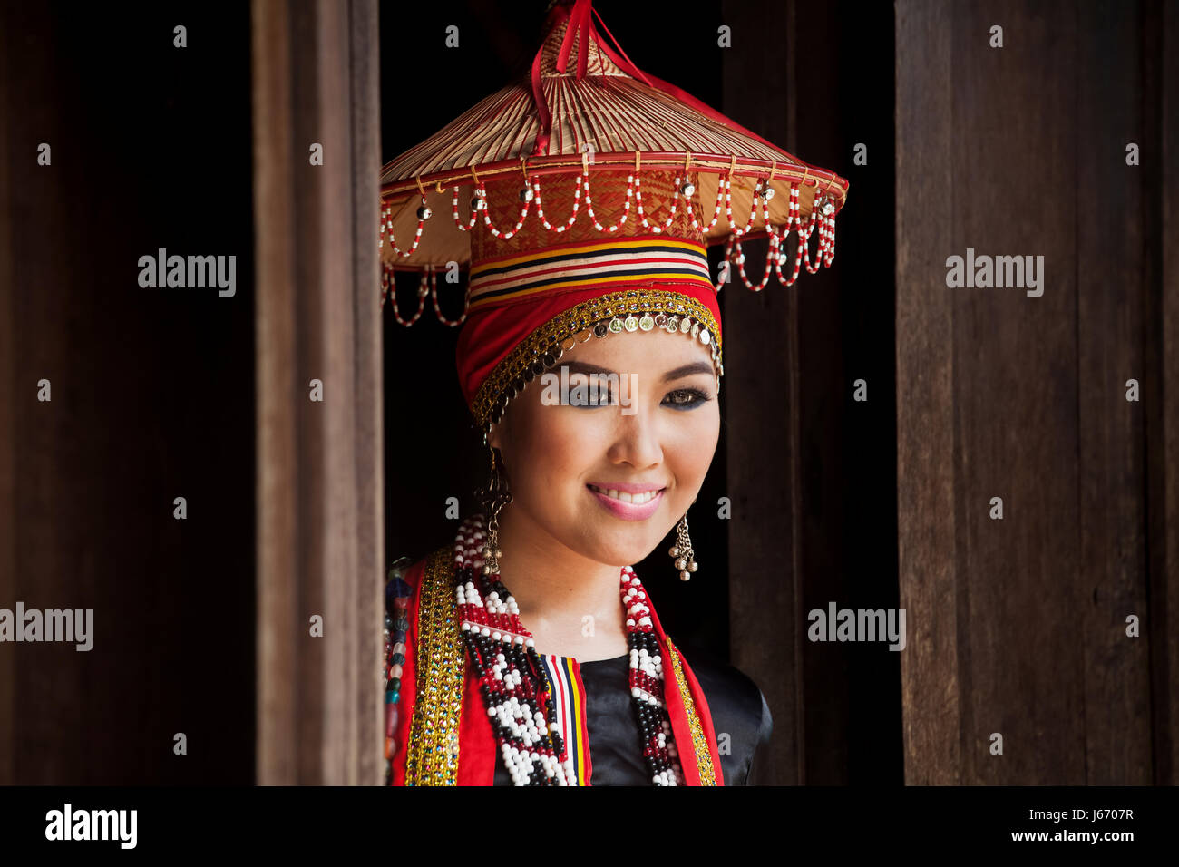 Volto ritratto di donna appartenente al Bidayu gruppo etnico di Dayaks visualizzazione allestita copricapo lungo con perline colorate e le monete in euro Foto Stock