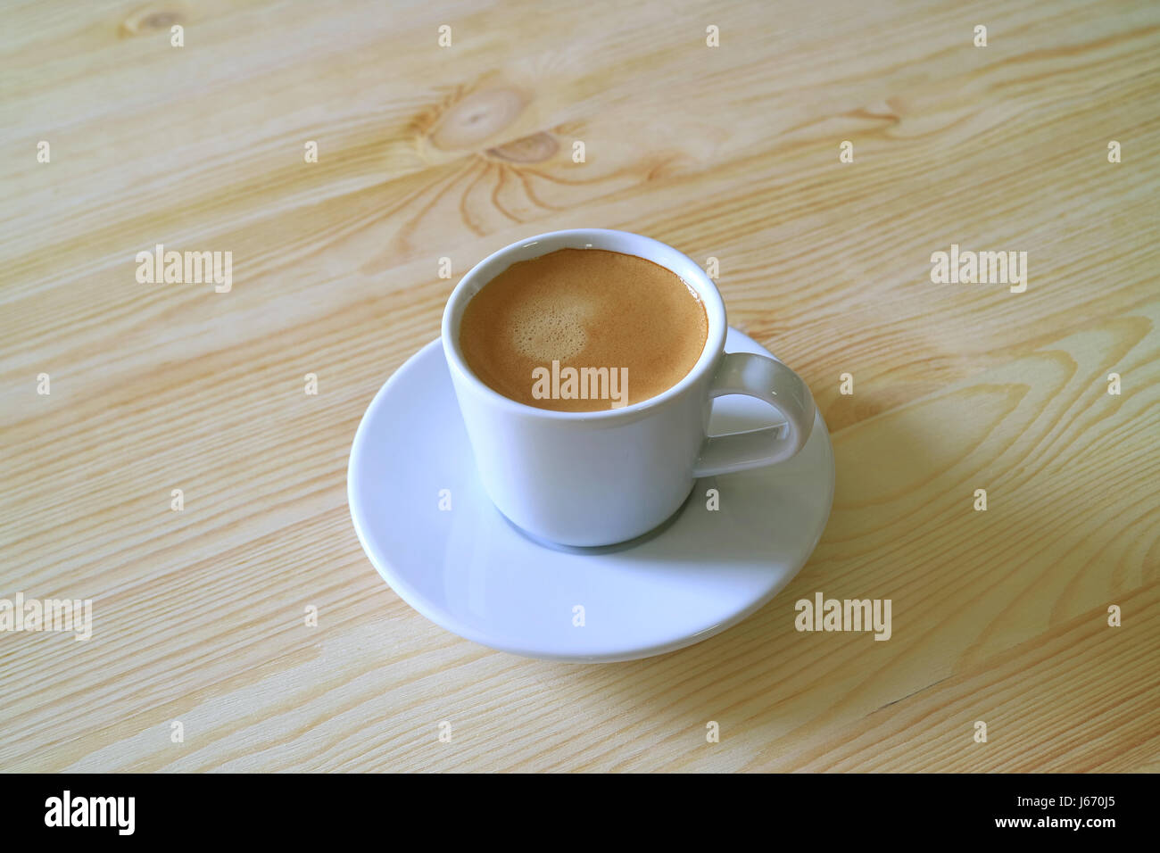 Una tazza di caffè caldo servito sul tavolo di legno Foto Stock