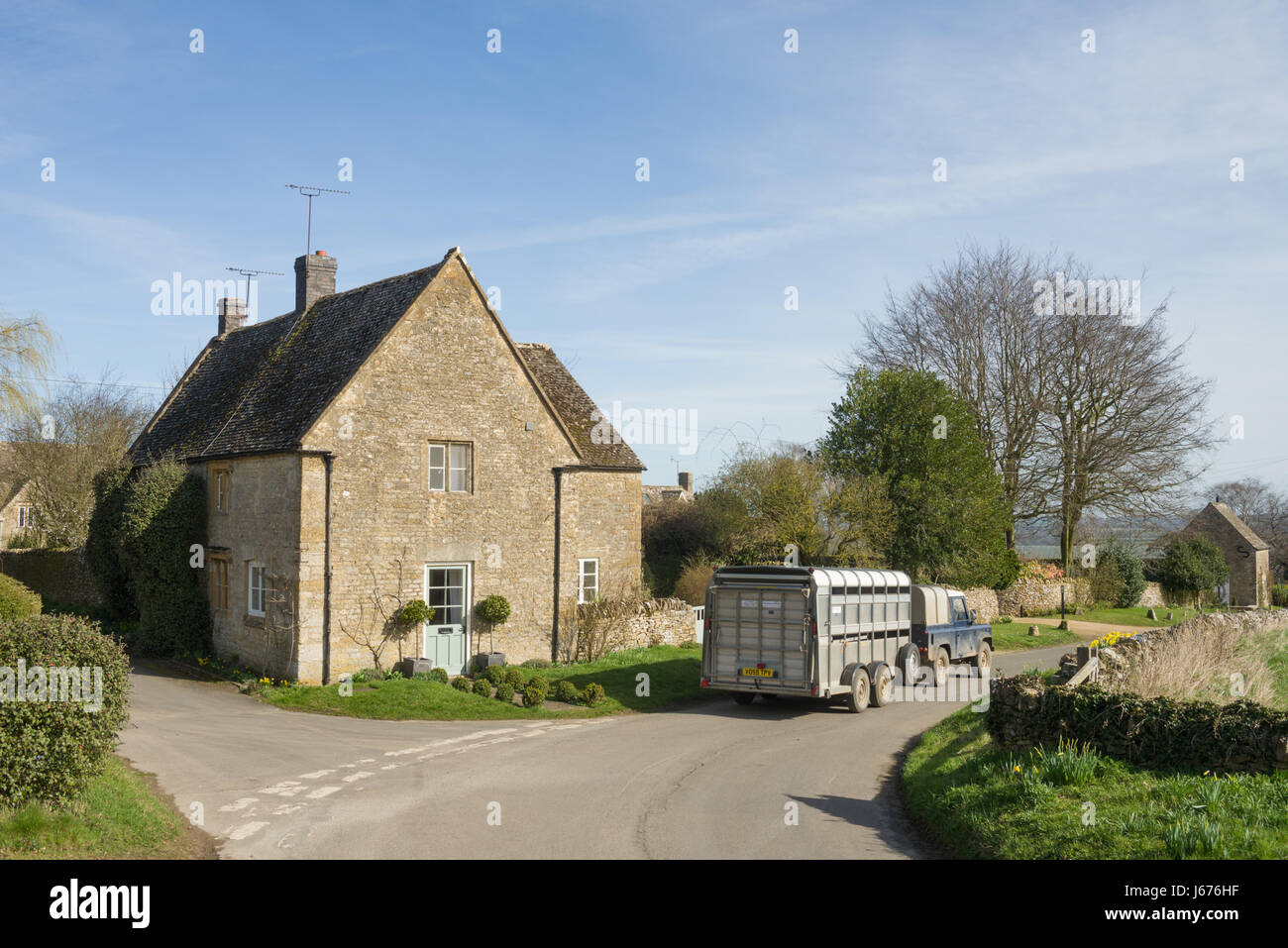 Una land rover defender con un rimorchio che viaggiano attraverso il Donnington, vicino Stow-su-il-Wold, Gloucestershire, England, Regno Unito Foto Stock
