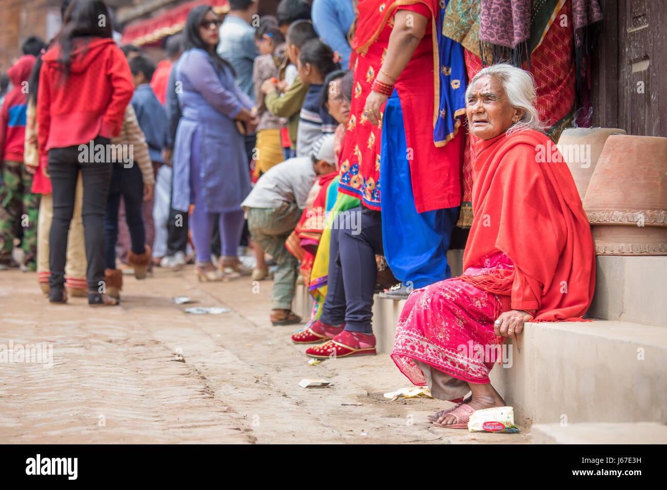 Kathmandu, Nepal - Apr 15, 2016: donne anziane nella tradizionale abbigliamento NEpalese guardando una cerimonia di passaggio processione. Foto Stock