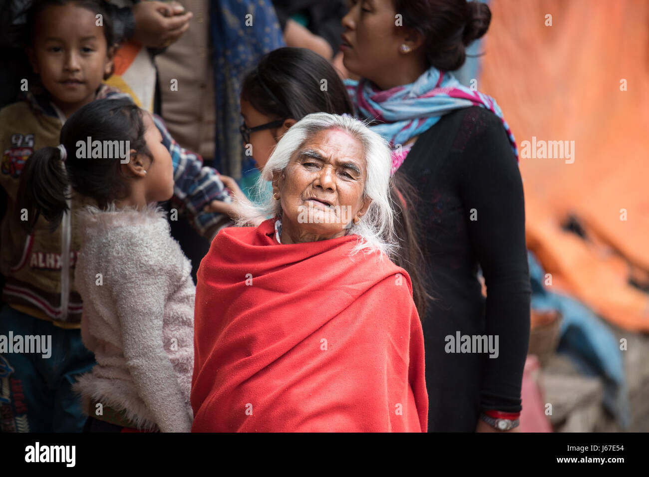 Kathmandu, Nepal - Apr 15, 2016: donne anziane nella tradizionale abbigliamento NEpalese guardando una cerimonia di passaggio processione. Foto Stock