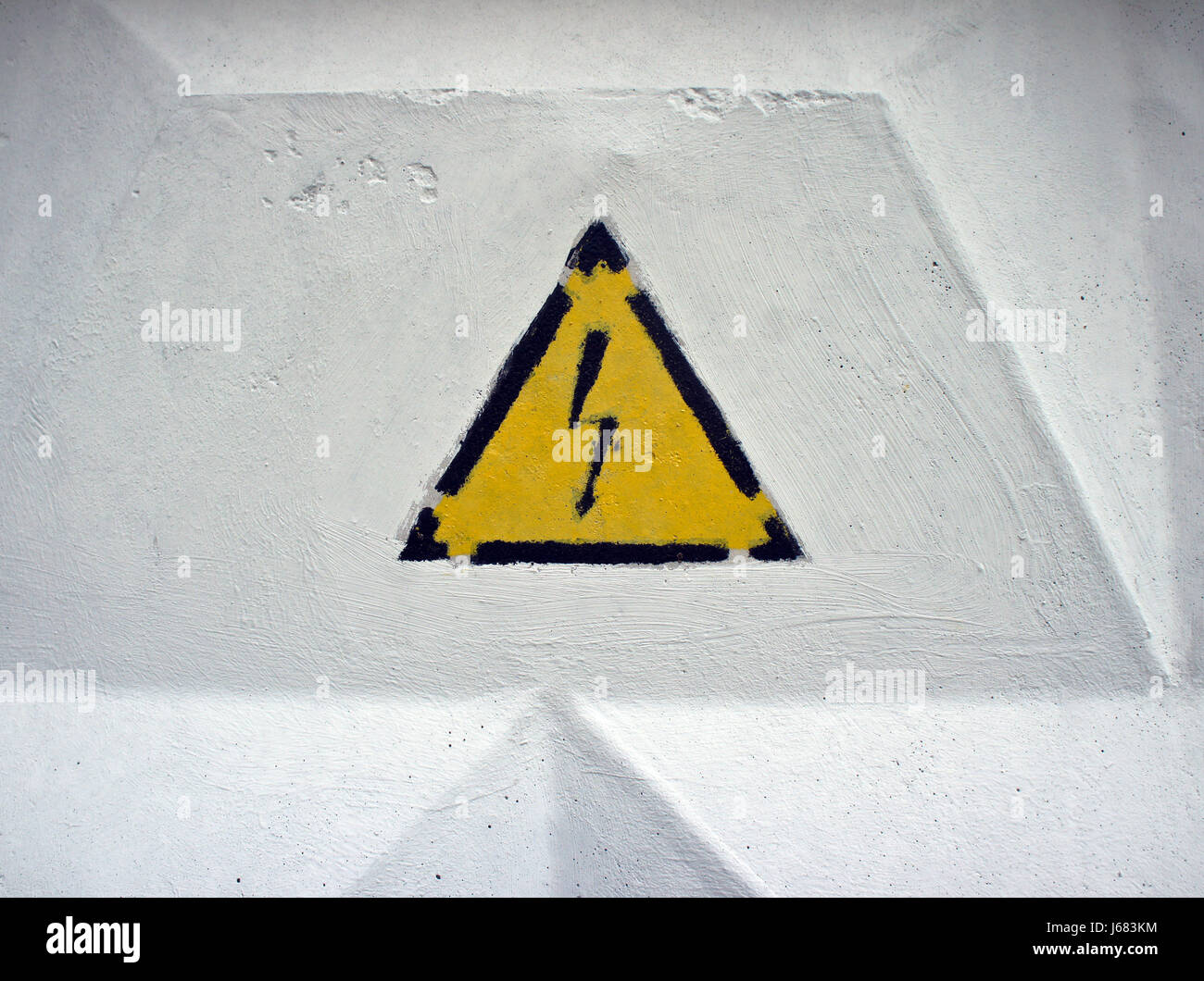 Pericolo alta tensione segnale di avvertimento. Bianco parete di calcestruzzo Foto Stock