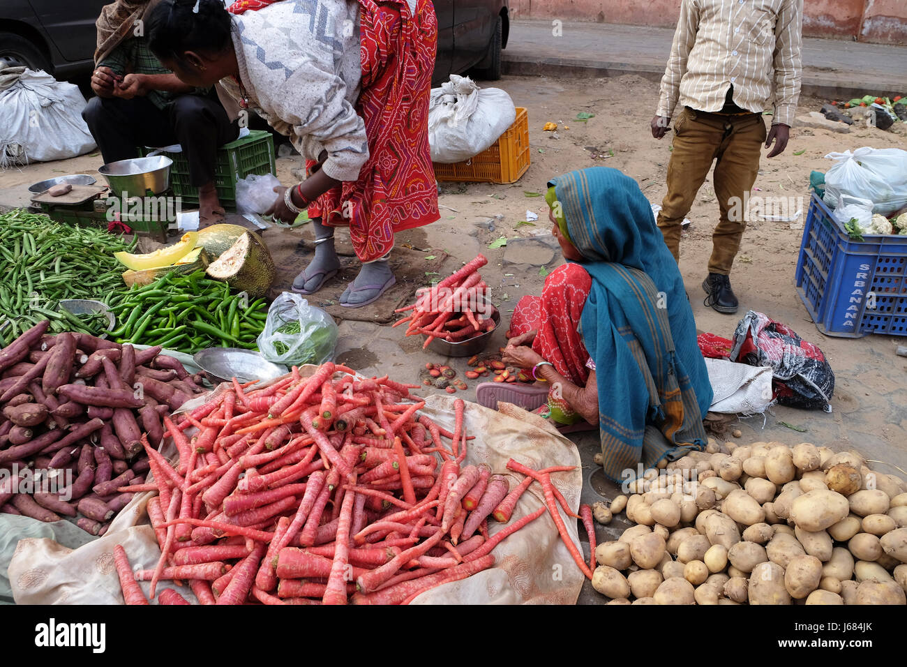 JAIPUR, India - 16 febbraio: le donne indiane in Colorati luminosamente sari per la vendita di frutta e verdura dal lato della strada a Jaipur, Rajasthan, India o Foto Stock